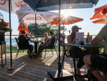 patrons enjoying a patio with lake in the background